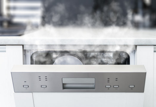 Open dishwasher with steam and clean dishes