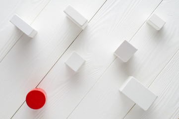Red and white wooden blocks on white wooden background