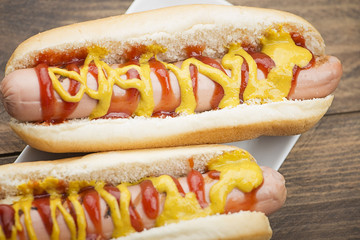 Close-up of two hotdogs on wooden table. Fastfood.