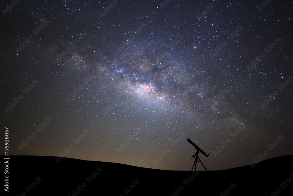 Wall mural silhouette of telescope watching the wilky way galaxy with stars and space dust in the universe