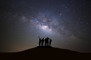 Obraz premium Krajobraz z galaktyką drogi mlecznej, rozgwieżdżone nocne niebo z gwiazdami i sylwetka ludzi stojących szczęśliwego człowieka na wysokiej górze.