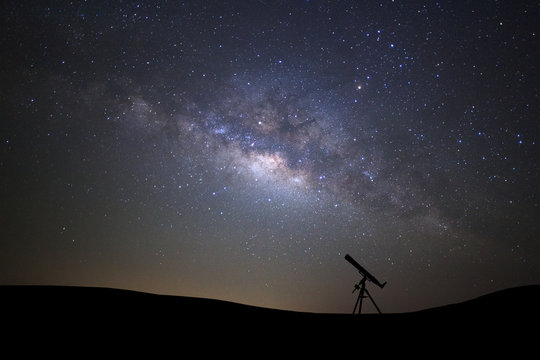 Silhouette of telescope watching the wilky way galaxy with stars and space dust in the universe