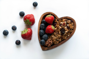 Healthy breakfast: homemade gramola with fresh blueberry and strawberry on white background