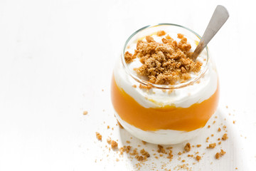 dessert with pumpkin, whipped cream and cookies on white table, top view
