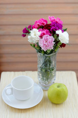 Flower bouquet, apple and coffee mug