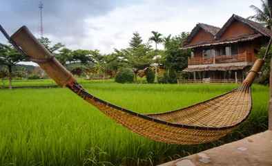 Bamboo hammock hangs on the balcony made of native material.
