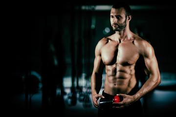Fototapeta na wymiar muscular guy drinks a protein in the gym