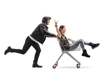 Biker pushing a shopping cart with a punk girl riding inside