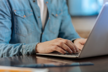 Close up of male hands typing on laptop