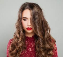 Beautiful Woman with Event Makeup and Long Healthy Wavy Hair. Portrait of Cute Young Model with Red Lips Makeup