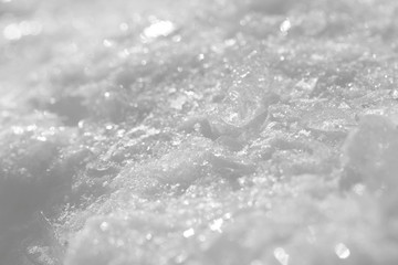 Texture of white snow with sparkles. Background for New Year's greeting card.