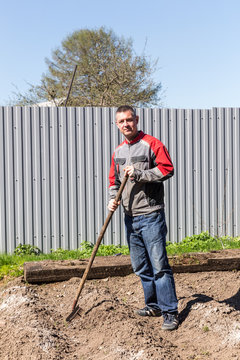 Man leveled seedbed rake in the garden