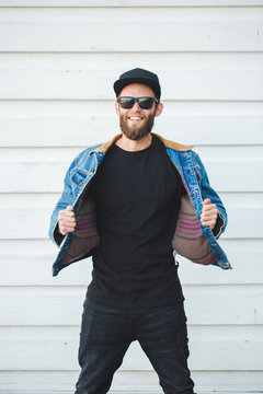 Hipster man walking wearing black jeans, t-shirt and a baseball cap