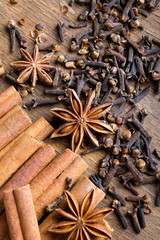 cinnamon sticks, star anise and cloves on wooden background