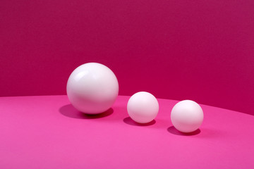 Abstract still life with white balls on a pink background