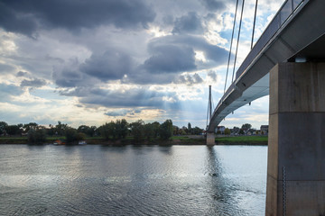 Fototapeta premium St Irinej bridge (Most Svetog Irineja) crossing Sava river in Sremska Mitrovica (Serbia) taken during an end of afternoon in autumn. Sremska Mitrovica is the main city of the Serbian Region of Srem.