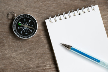 Blank note paper with compass on wood desk background