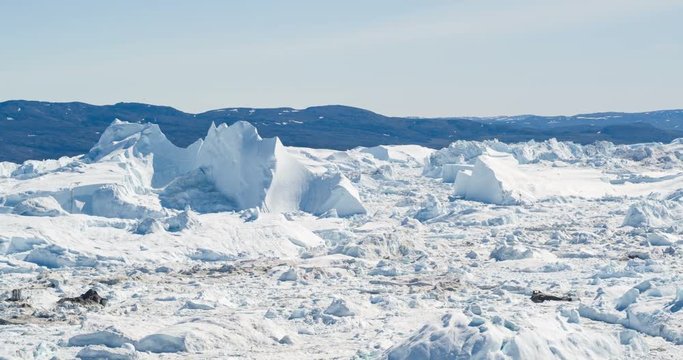 Climate Change and Global Warming - Icebergs from melting glacier in icefjord in Ilulissat, Greenland. Aerial video of arctic nature ice landscape.