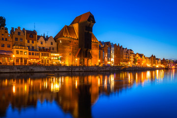 Naklejka premium Gdansk at night with historic port crane reflected in Motlawa river, Poland