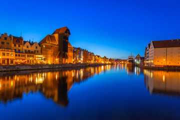 Gdansk at night with historic port crane reflected in Motlawa river, Poland
