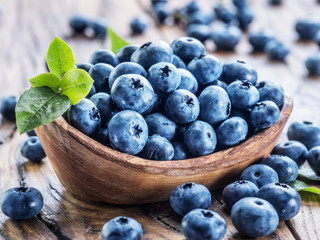 Blueberries in the wooden bowl on the table.