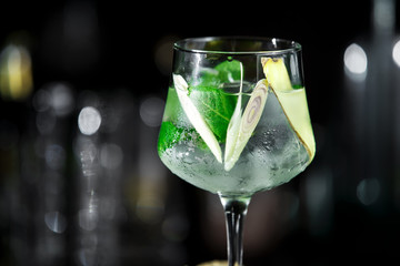 Ginger cocktail on dark background with mint and ice