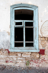 The facade of an abandoned house. Broken window, wooden frames.