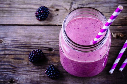 blackberry smoothie in a mason jar on a wooden rustic background