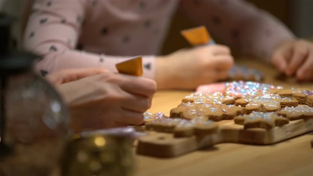 Young mother and her cute little daughter prepare Christmas cookies. Close up of hends