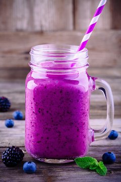 blackberry and blueberry smoothie in a mason jar on a wooden rustic background