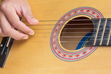 men's hands playing classical guitar, close up