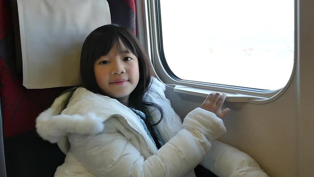Little asian girl looking through window. She travels on a train slow motion 26