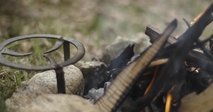 Detail of fireplace and woman putting glass on fire. Autumn outdoor trip in nature. Fall sunny day. 4k slow motion video