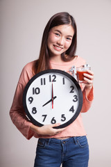 Young Asian woman with tomato juice and clock.