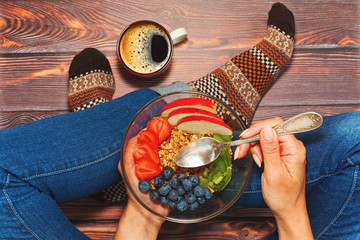 Person having breakfast cross-legged on wooden floor