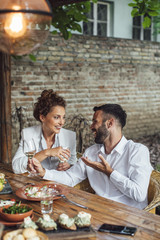 Couple Enjoying Wine and Food at Restaurant