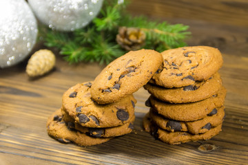 Chocolate chip cookies in front of Christmas decoration on wooden table