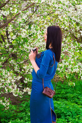 A young woman with retro camera photographing a blue dress