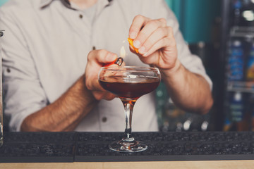 Young bartender making flaming cocktail