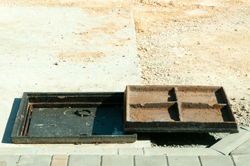 New metal cover over concrete manhole at road construction site close up