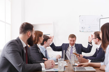 Dealing meeting at wooden table. Male boss emotional speech