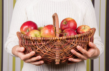 Woman holding a basket full of apples