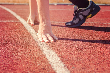 Runner in start position. Hands on starting line.