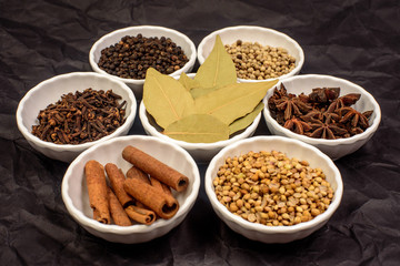 herbs and spices in a cup and dark background