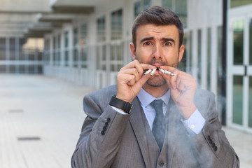 Stressed out businessman smoking four cigarettes at the same time