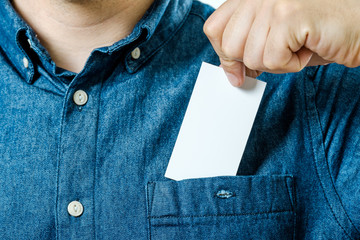 Man's hand takes out blank business card from the pocket