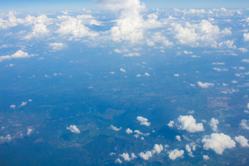 Sky, clouds and ground taken from the window of the plane.