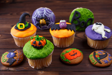 Composition with tasty homemade Halloween sweets with decorations made of confectionery mastic on the table, close up. Halloween treats, holiday food concept