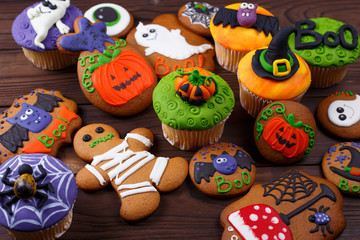 Halloween homemade gingerbread cookies and cupcakes background. Great assortment for treats at...