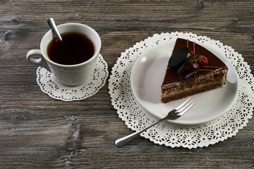Delicious chocolate cake with berries and cup of tea